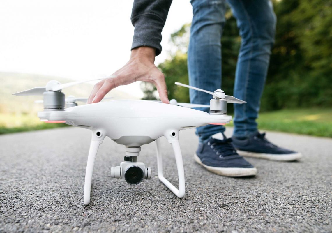 unrecognizable-man-with-drone-sunny-green-nature-c-PKFLLWC.jpg