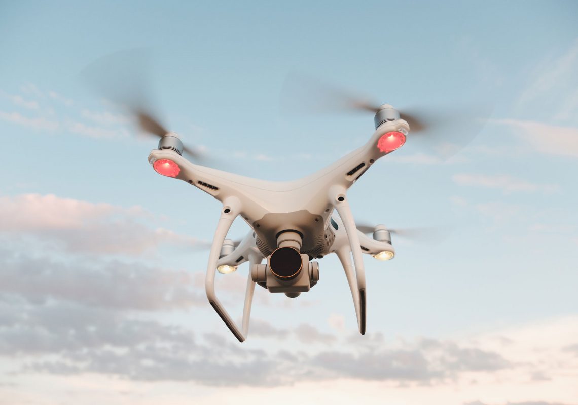 white-drone-hovering-in-a-bright-blue-sky-PMFRLG7.jpg